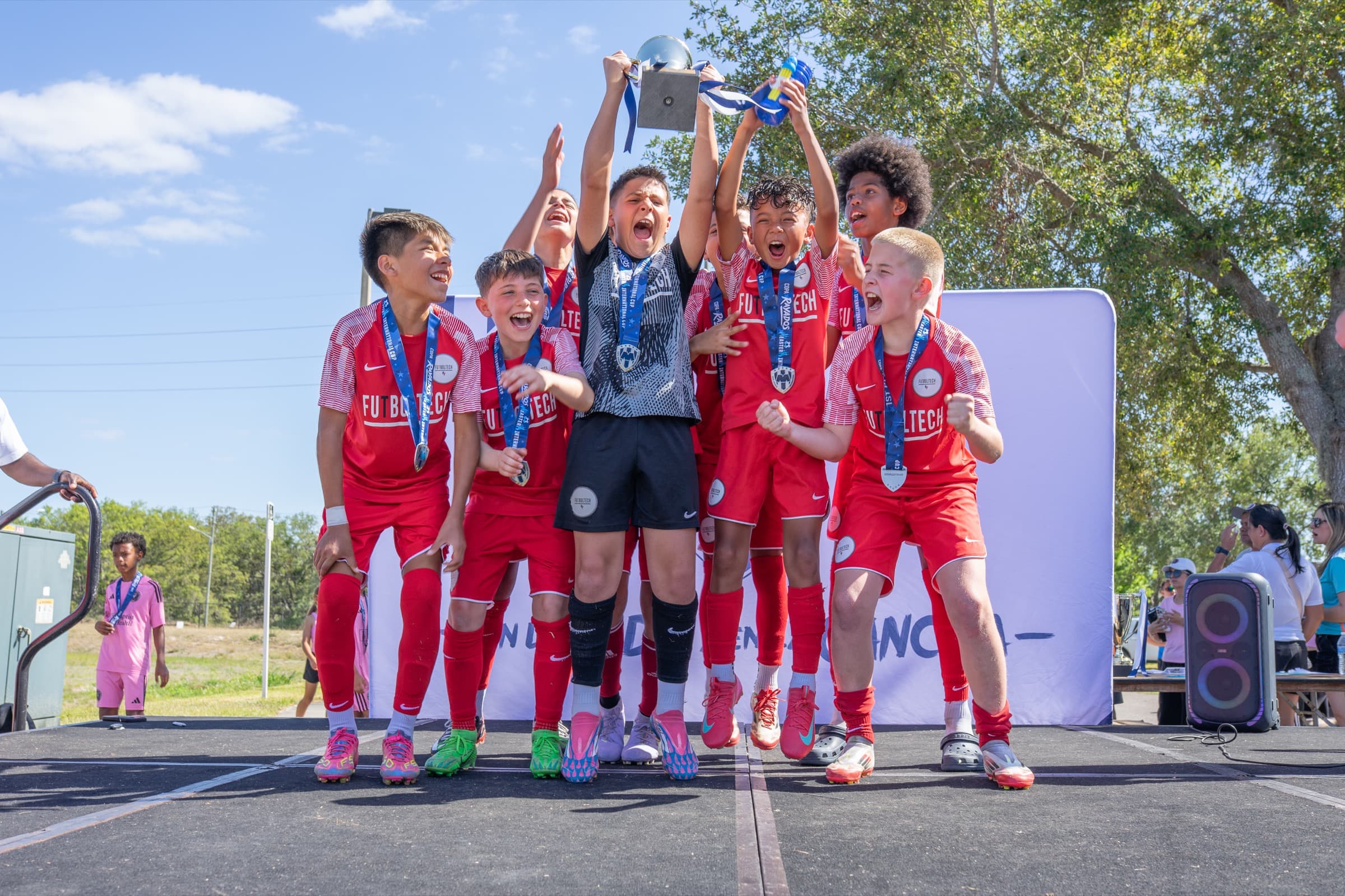 Players celebrating their tournament together with medals and a trophy